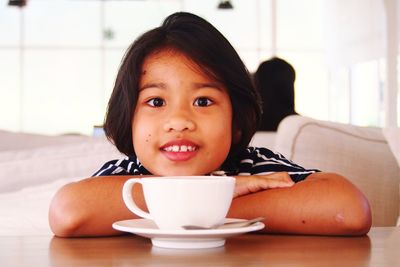 Portrait of girl having coffee at table