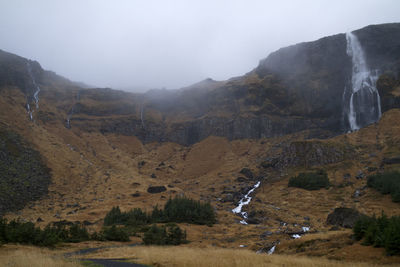 Scenic view of waterfall against sky