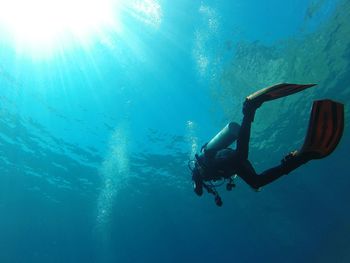 Low angle view of woman scuba diving in sea