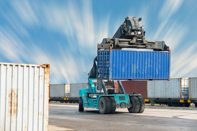 Stack of truck on metallic structure against sky