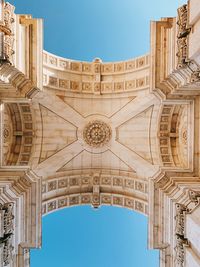 Directly below shot historical building against clear blue sky