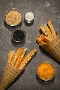 Salted cheese straws and sesame seeds in a paper cone