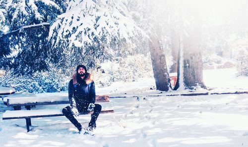 Full length of woman on snow covered tree