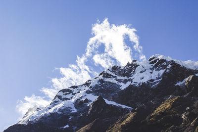 Low angle view of snowcapped mountains against sky