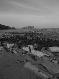 Surface level of rocks on shore against sky