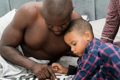 Father reading a book for his son in bed