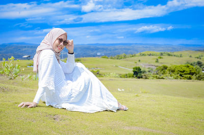 Portrait of woman standing on road against sky