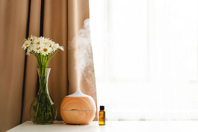 Aromatherapy concept. aroma oil diffuser on the table against the window.