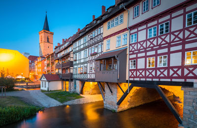 View of building by river against sky in city