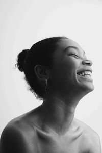 Close-up of smiling young woman against white background