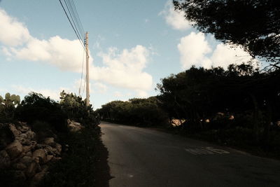 Road amidst trees against sky