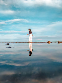 Woman with arms raised against sky