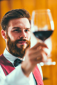 Close-up sommelier holding wine in glass