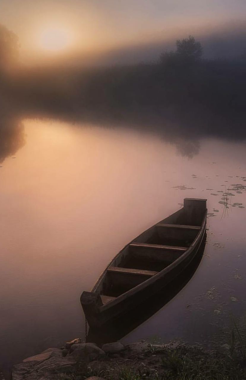 BOAT MOORED IN CALM LAKE