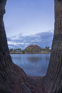 Scenic view of river against cloudy sky