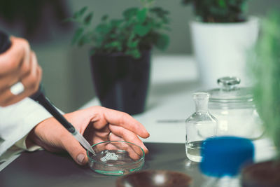 Cropped hands of female scientist experimenting in laboratory