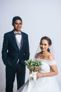 Young couple standing against clear sky