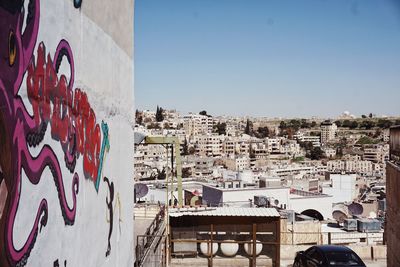 Graffiti on wall against buildings in city