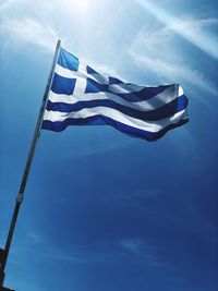 Low angle view of flag against blue sky