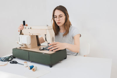 Young woman holding camera on table