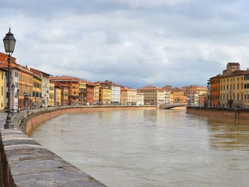 River by buildings in town against sky