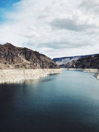 Scenic view of lake by mountains against sky