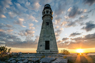 Lighthouse against cloudy sky at sunset