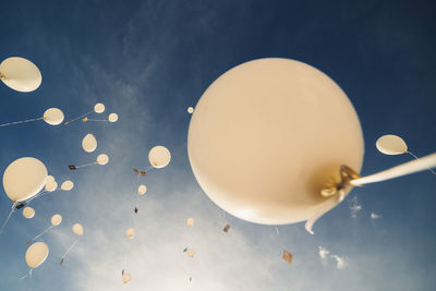 White balloons fly up into the blue sky. the release of festive balloons in the clouds. celebration
