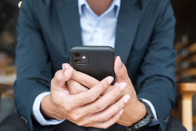 Midsection of man using mobile phone