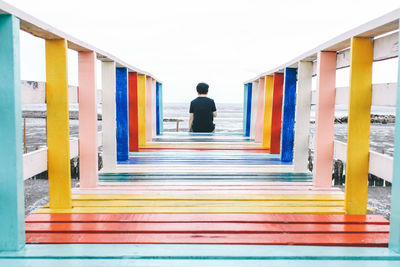 Rear view of woman standing against multi colored building