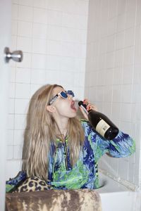 Young woman wearing mask in bathroom