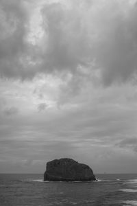 Rock formation in sea against sky