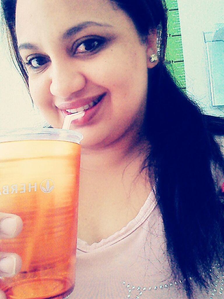 CLOSE-UP PORTRAIT OF SMILING YOUNG WOMAN DRINKING GLASSES OUTDOORS