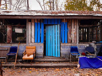 Empty chairs and tables against building