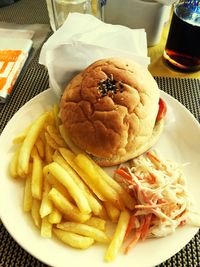 Close-up of burger and fries in plate on table