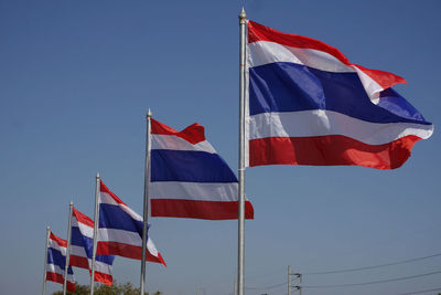 Low angle view of flags against clear sky