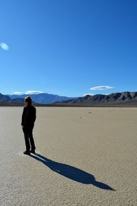 Full length of man standing on desert against sky