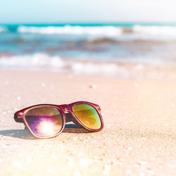 Close-up of sunglasses on beach