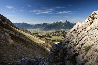 Scenic view of valley and mountains against sky