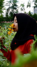 Side view of woman wearing red flower