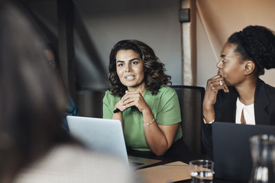 Mature businesswoman discussing in meeting with female colleagues at office