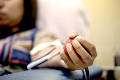 Midsection of mid adult woman holding stress ball on hospital bed