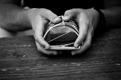 Cropped image of man shuffling cards at table