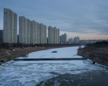 View of cityscape during winter against sky