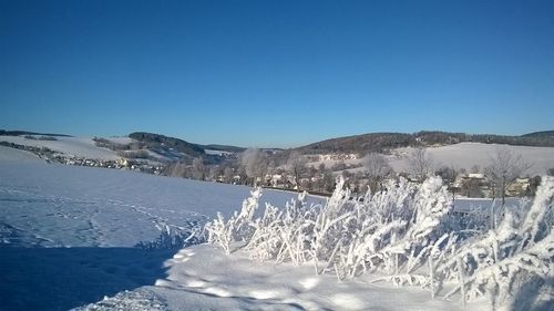 Panoramic view of snowcapped mountains against clear blue sky