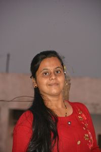 Portrait of young woman standing against wall