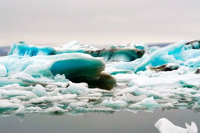 Frozen lake against sky during winter