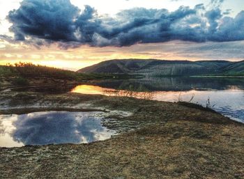 Scenic view of lake against cloudy sky