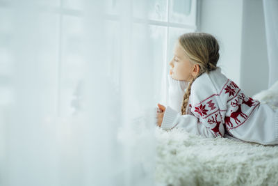 Side view of mother carrying daughter at home