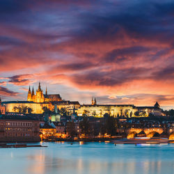 Illuminated buildings in city at sunset